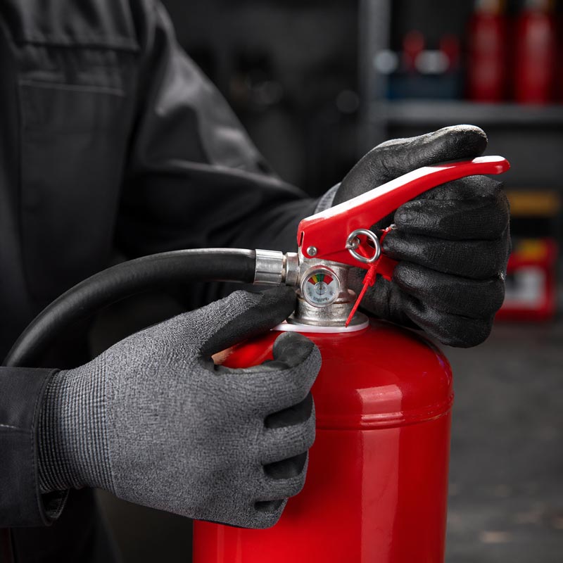 Portable fire extinguisher being inspected before recharging