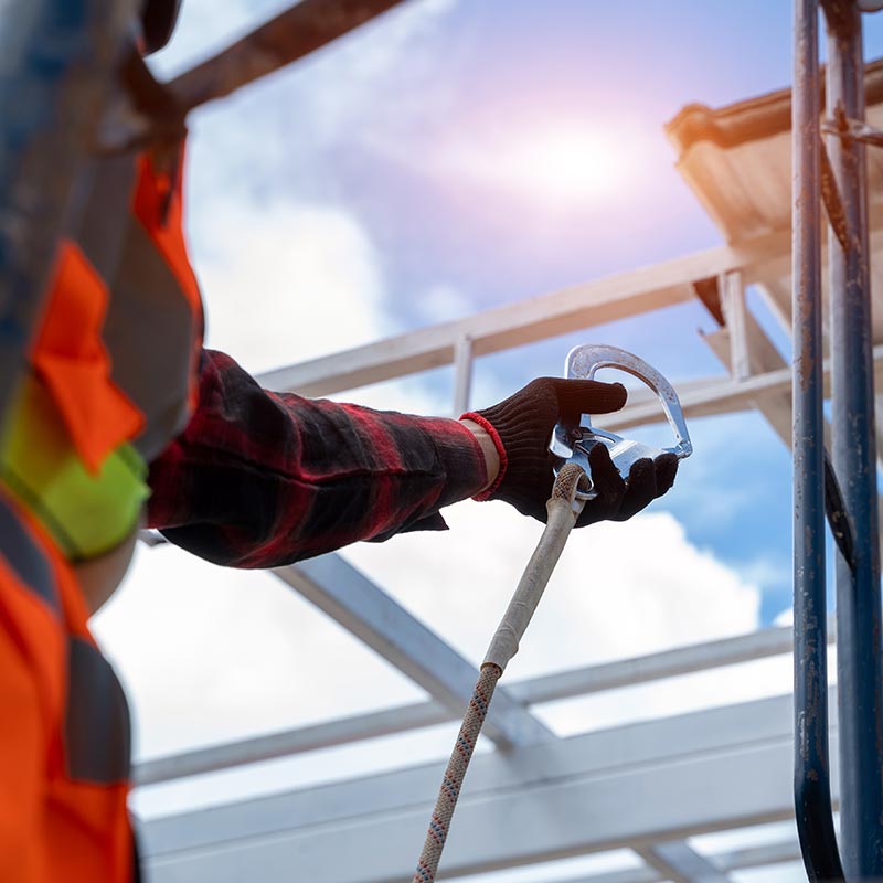 Fall protection harness and lanyard being inspected before use